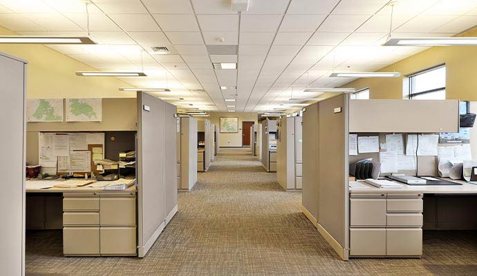 A wide interior view of a professional office space featuring rows of cubicles