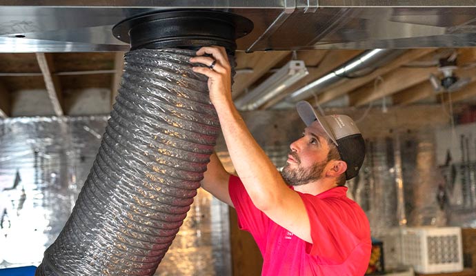 A person opening a flexible duct ventilation pipe