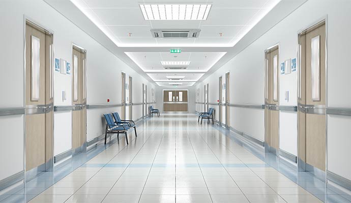 Sanitized healthcare hallway with polished floors and patient room doors.